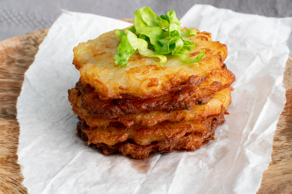 image of potato pancakes on parchment paper for the cook with potatoes blog.