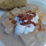 image of potato soup topped with sour cream and bacon.
