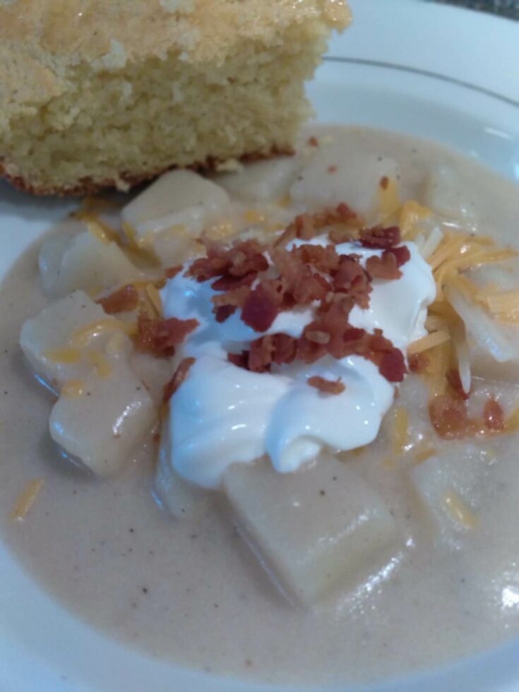 image of potato soup topped with sour cream and bacon.