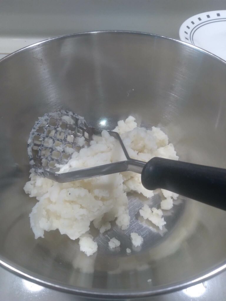 image of potato masher and mashed potatoes.